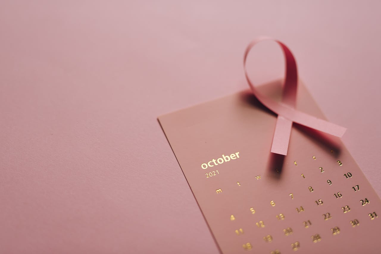 about-us Pink ribbon on October 2021 calendar symbolizing breast cancer awareness.